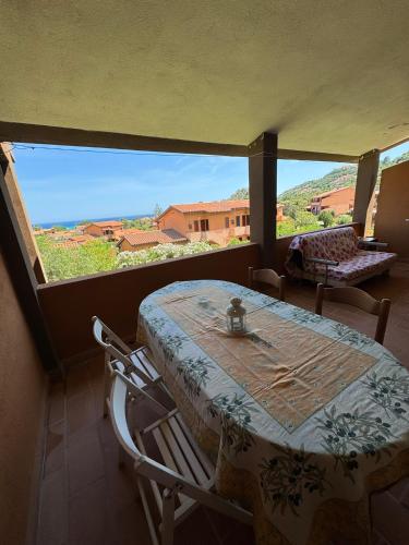 a table and chairs in a room with a large window at Villetta Amare Sardegna in Costa Rei