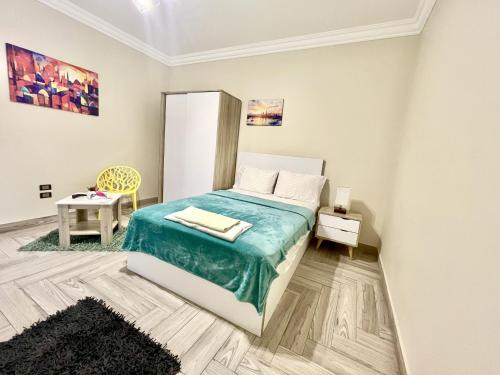 a bedroom with a bed with a blue blanket at Rose Room in Cairo