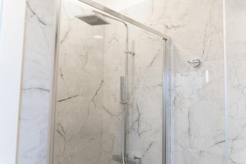 a shower with a glass door in a bathroom at BeBaia in Leporano Marina