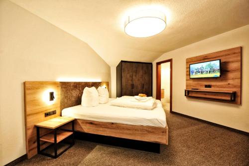 une chambre d'hôtel avec un lit et une télévision dans l'établissement Haus Enzian, à Fiss