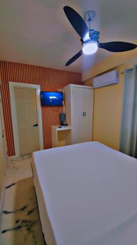 a room with a ceiling fan and a room with a kitchen at Very comfortable in Saint Georgeʼs