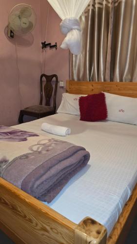 a bedroom with a bed with a wooden head board at Okla GuestHouse in Kampala