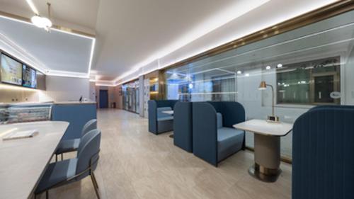 a waiting room with blue chairs and a table at Hanting Hotel Beijing Wanfeng Road Qilizhuang Subway Station in Beijing