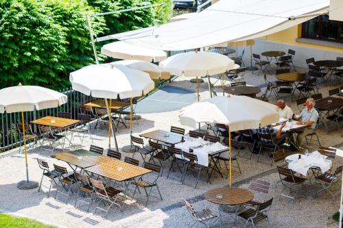 an overhead view of tables and chairs with umbrellas at Hotel Bleichibeiz in Wald