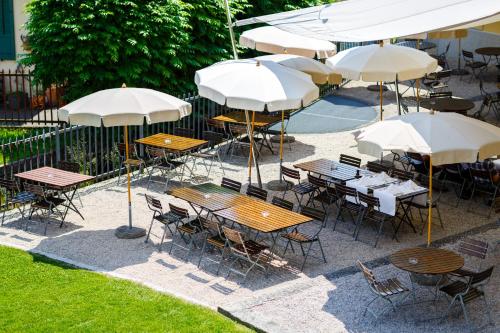 an outdoor patio with tables and chairs and umbrellas at Hotel Bleichibeiz in Wald