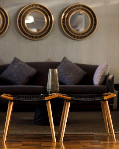 a living room with a couch and two coffee tables at Mantis Akagera Game Lodge in Akagera