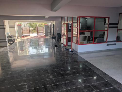a large room with a tile floor and red doors at Hotel Virat Stay in Hyderabad