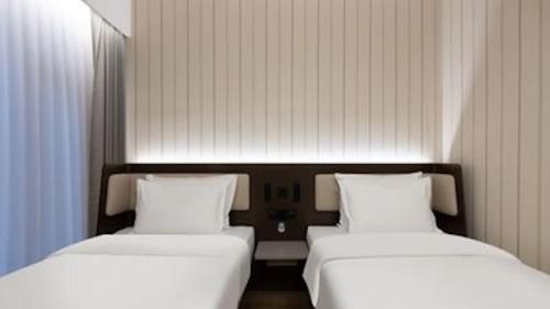 two beds sitting next to each other in a room at Hanting Hotel Beijing Wanfeng Road Qilizhuang Subway Station in Beijing