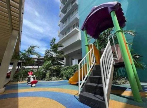 a playground in a building with a slide at Reflective Woodscape- 1 Bedroom with Balcony in Bacolod