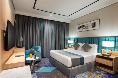 a hotel room with a bed and a chair at فندق رينيوم - جازان in Jazan
