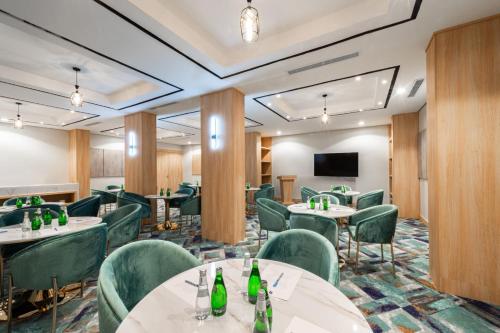 a conference room with tables and chairs and a flat screen tv at فندق رينيوم - جازان in Jazan