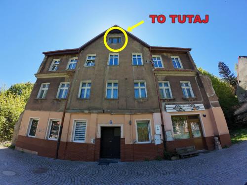 a building with a yellow circle on top of it at Studio z widokiem na park in Srebrna Góra