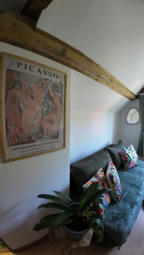 a living room with a blue couch and a painting at Studio z widokiem na park in Srebrna Góra