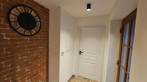 a clock on a brick wall next to a door at Boutique wine rezidence in Hnanice