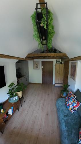 an attic living room with a couch and a staircase at Studio z widokiem na park in Srebrna Góra