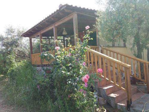 a small house with a wooden porch with flowers at Campus Verde in Eleftheres
