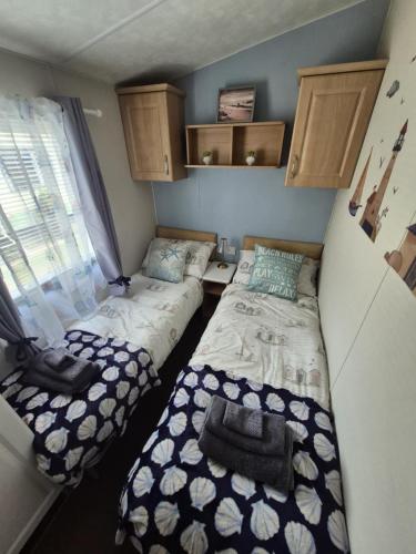 a small room with two beds and a window at The island escape isle of wight in Porchfield
