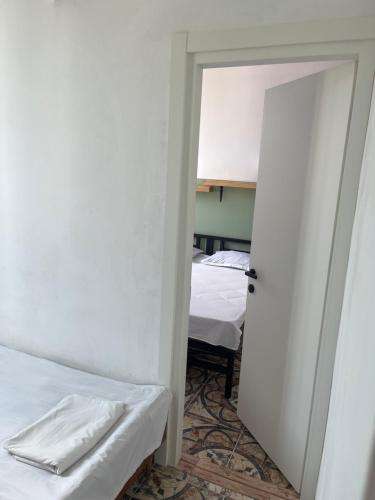 a room with two beds and an open door at Olympia Ureki Guria Street 24-26 in Ureki