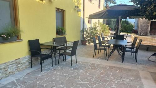 a patio with tables and chairs and an umbrella at Apartmaji Tinta in Kanal