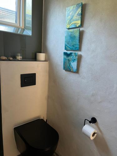 a bathroom with a black toilet and a roll of toilet paper at Winding B&B Silkeborg in Silkeborg