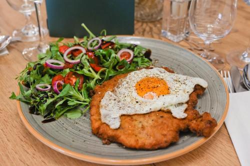 a plate of food with an egg and a salad at Penzión Zlatny Potok in Mutné