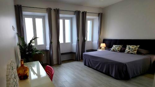 a bedroom with a bed and a table and windows at City Garden Villa , Ponta Delgada in Ponta Delgada