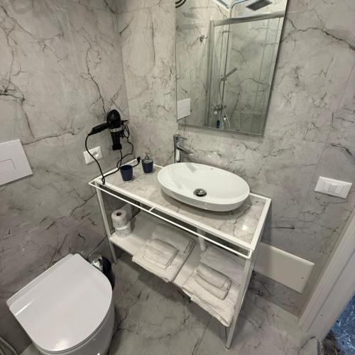 a bathroom with a sink and a toilet and a mirror at BeBaia in Leporano Marina