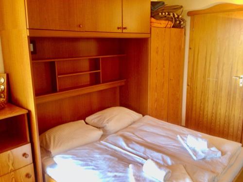 a small bed in a small room with wooden cabinets at Grosse-Ferienwohnung-Pool-Sauna-Hallenbad-Wintersport-bei-Passau in Hauzenberg