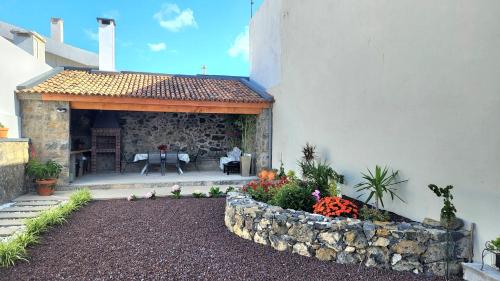 a patio of a house with a stone wall at City Garden Villa , Ponta Delgada in Ponta Delgada