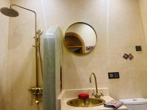 a bathroom with a sink and a shower with a mirror at Riad Qasr El Medina in Tangier
