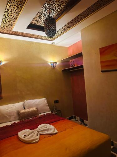 a bedroom with a bed with a robe on it at Riad Qasr El Medina in Tangier