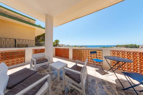 a balcony with a table and chairs and the ocean at BeBaia in Leporano Marina