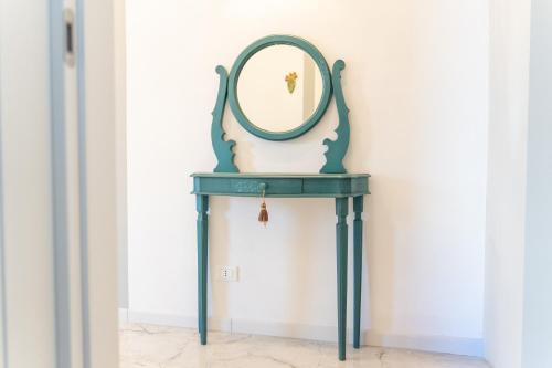 a green console table with a mirror on it at BeBaia in Leporano Marina
