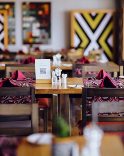 a table in a restaurant with tables and chairs at Mantis Akagera Game Lodge in Akagera