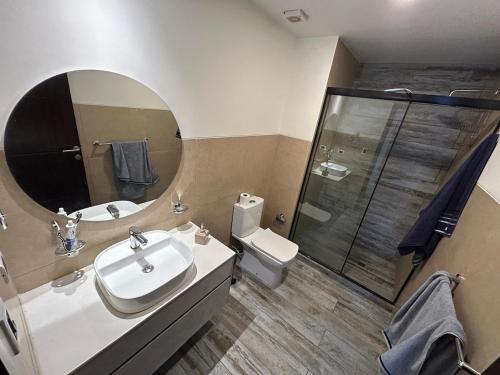 a bathroom with a sink and a mirror and a shower at Amplio, Familiar y Acogedor in Cochabamba