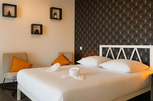 a bedroom with a white bed with two towels at Le Privilège Cosy Central Chic in Le Creusot