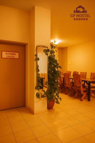 a waiting room with a table and a potted plant at GP Hostel in Šiauliai