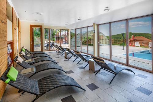 a row of chairs in a room with a pool at Szalajka Liget Hotel és Apartmanházak in Szilvásvárad