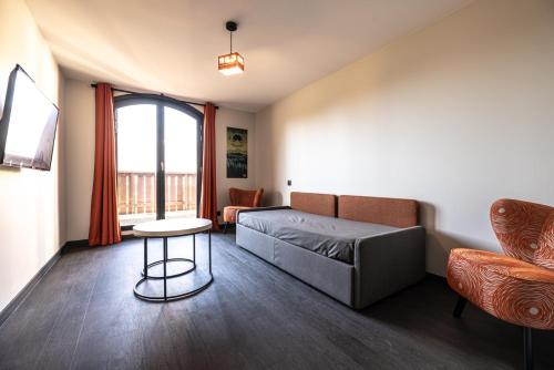 a living room with a bed and a table at Hotel Base Camp Lodge - Albertville in Albertville
