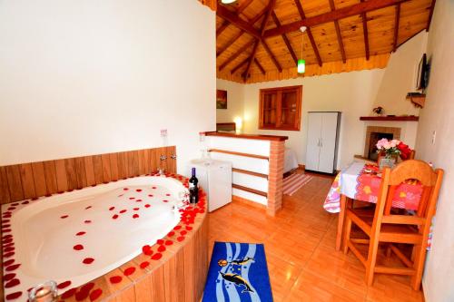 a large bath tub in a room with a kitchen at Pousada Cantinho Colibri in Monte Verde
