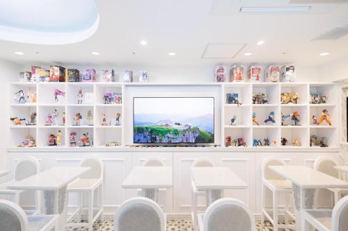 a room with white chairs and a picture on the wall at Hotaku HOTEL Akihabara in Tokyo