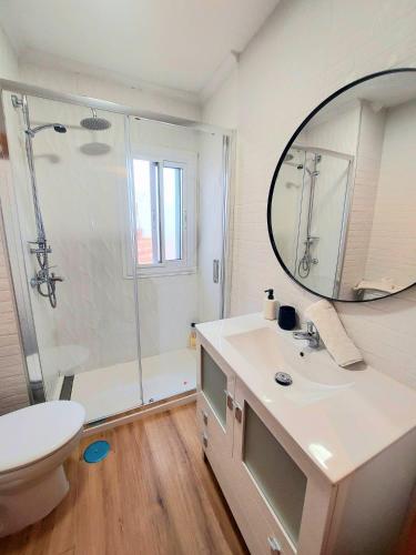 a bathroom with a shower and a sink and a mirror at San Pagés 3BR Apartment in Seville