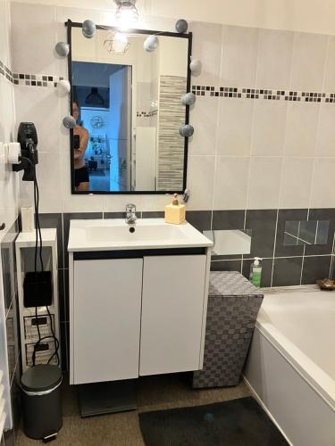 a bathroom with a white sink and a mirror at BLUE HORIZON T4 3 bedrooms Panoramic sea view in Saint-Raphaël