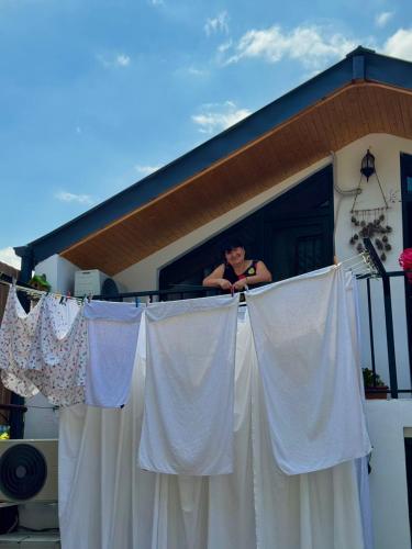 a woman standing on a balcony looking out of a window at Nitsa Guest House in Gori