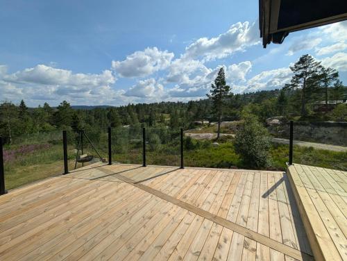 a wooden deck with a view of the woods at Modernized Mountain Cabin Near Treungen in Drangedal