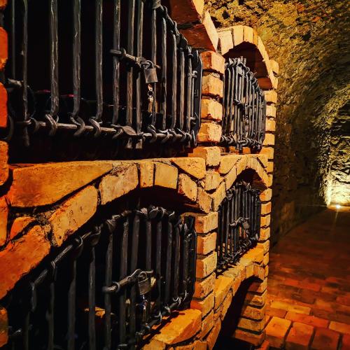 a brick wall with black wrought iron gates at Boutique wine rezidence in Hnanice