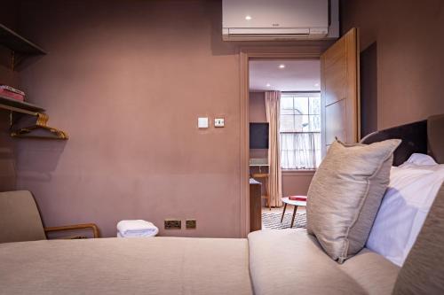a room with a bed and a couch and a window at The Rokxy Townhouse & Residences - Kings Cross in London