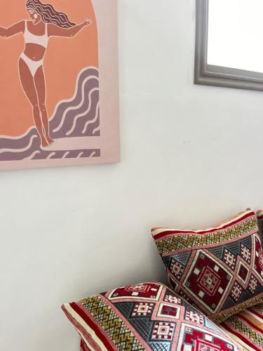 a bed with a pillow and a picture of a woman on a surfboard at Casa Z Morocco in Tamraght Ouzdar