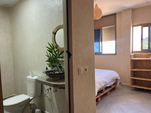 a bathroom with a toilet and a bed in a room at Casa Z Morocco in Tamraght Ouzdar