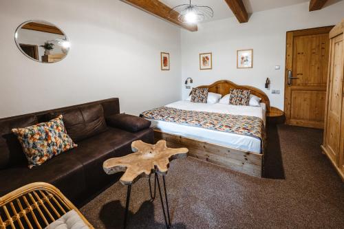a bedroom with a bed and a leather couch at Hotel Frýdl in Prague